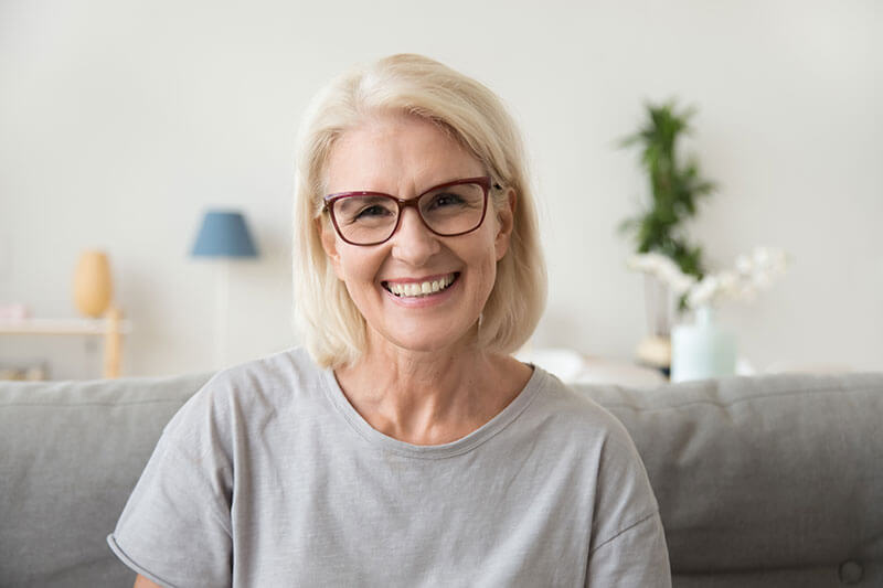 older woman with glasses smiling