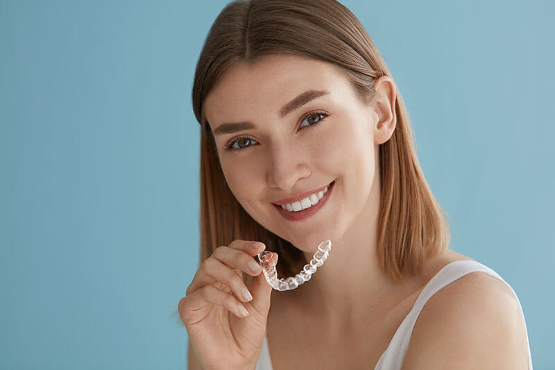 woman holding her Invisalign tray